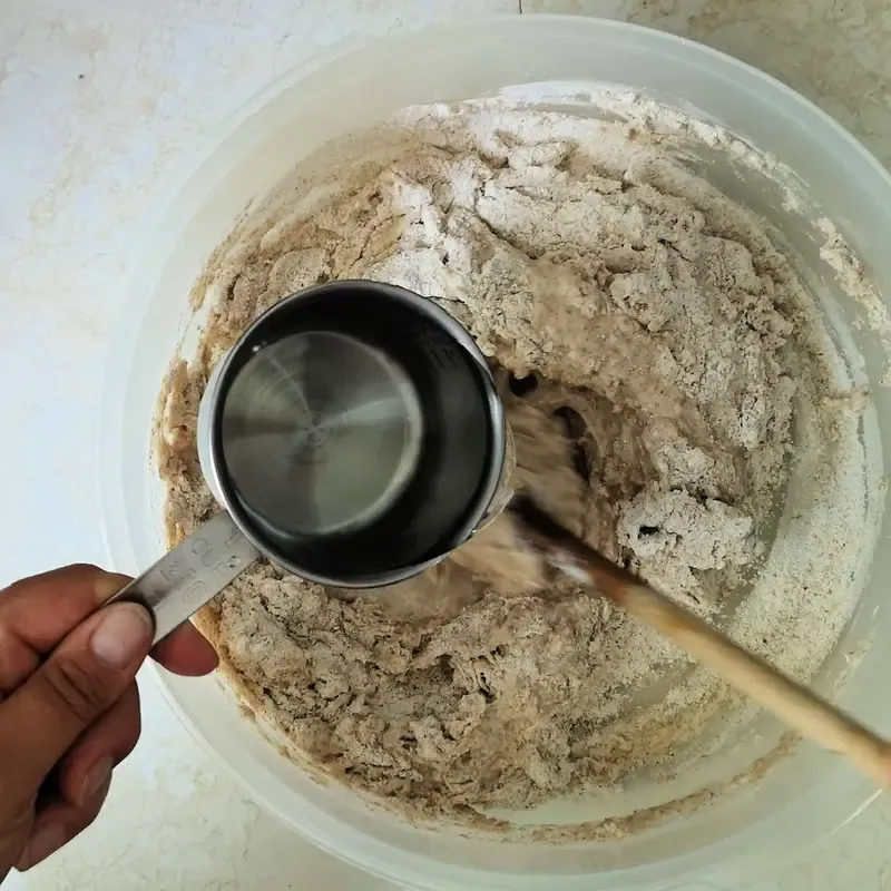 Mehl und Wasser zum Sauerteig geben