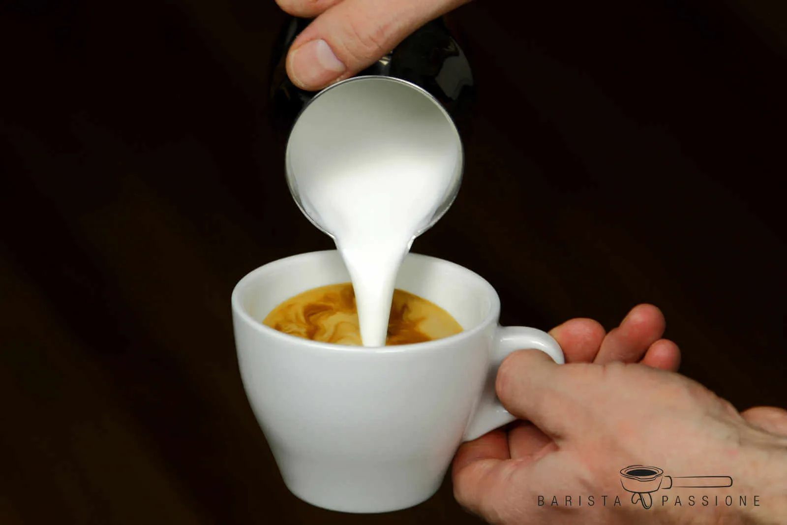 Milchschaum in Cappuccino eingießen