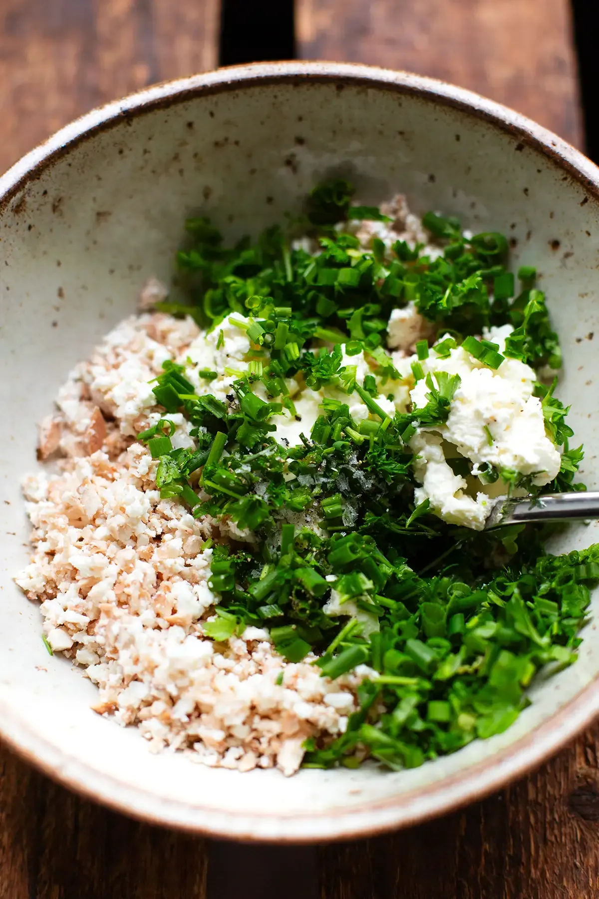 Nahaufnahme der cremigen Frischkäse-Feta-Füllung für Champignons, vermischt mit gehackten Pilzstielen und Kräutern