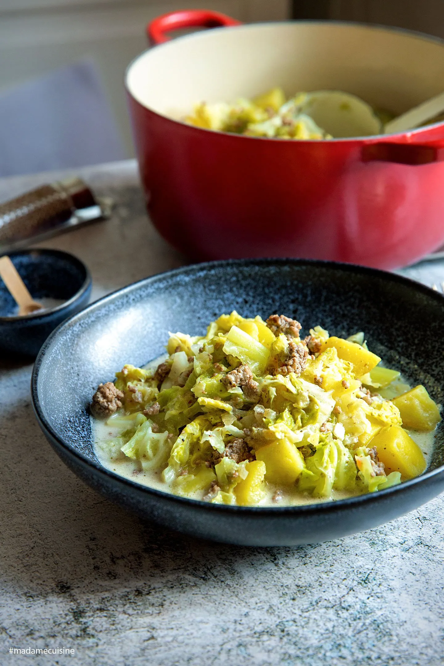 Nahaufnahme des dampfenden Wirsing-Eintopfs mit Hackfleisch, Kartoffeln und frischen Kräutern in einem Topf