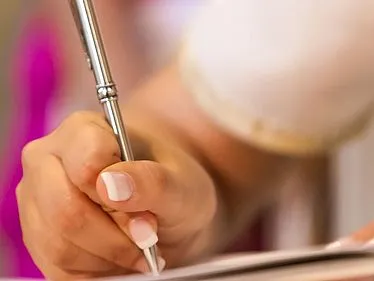 Nahaufnahme einer Hand, die ein Dokument unterschreibt, symbolisiert das Engagement für verantwortungsvolle Lieferketten.