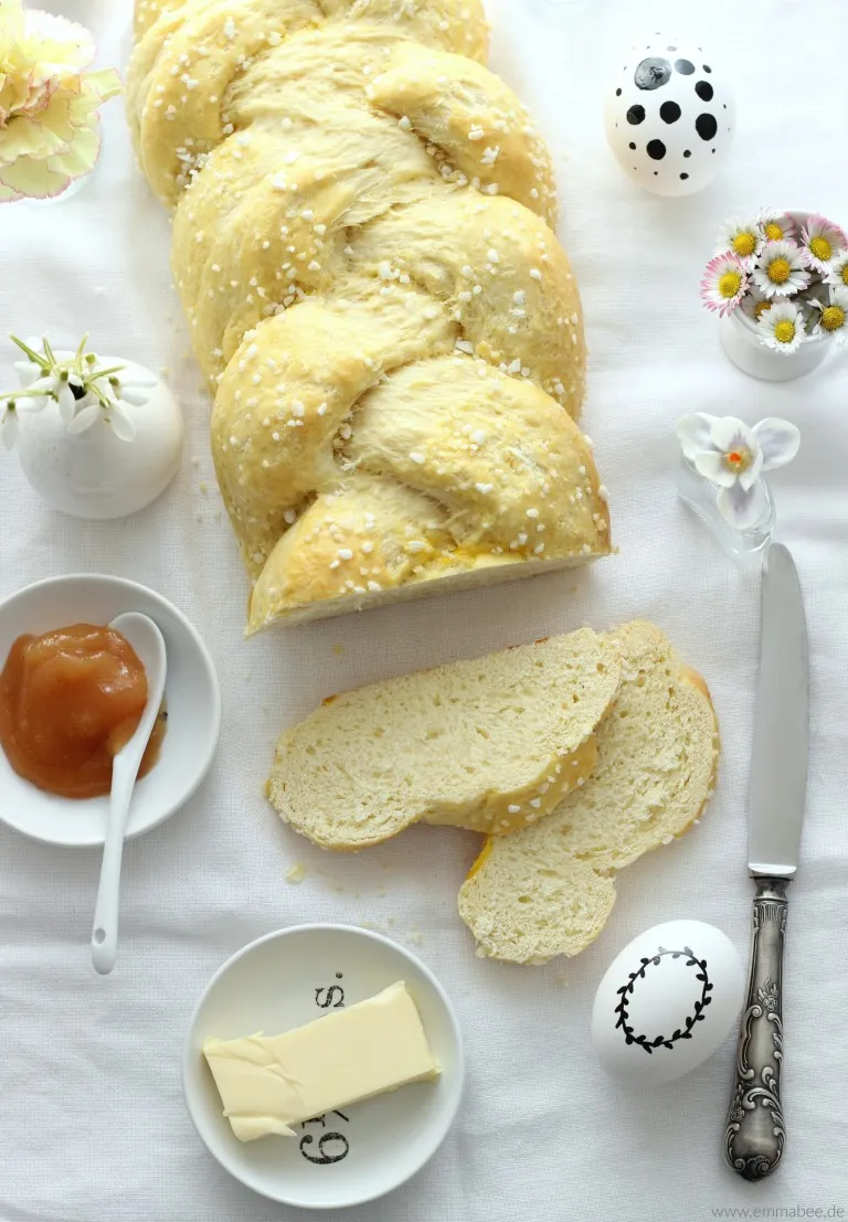 Nahaufnahme eines Hefezopfes, dessen Teig noch sichtbar ist und mit Hagelzucker bestreut wurde, bereit zum Backen