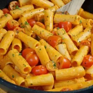 Nahaufnahme eines Tellers mit cremiger Tomaten-Mascarpone-Sauce und Nudeln, garniert mit frischer Petersilie und Parmesan.