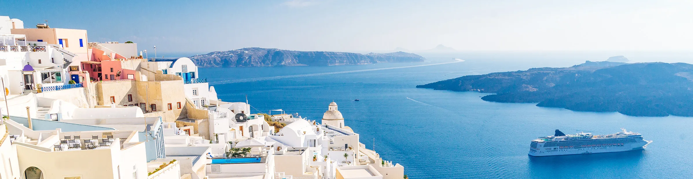 Panoramablick auf die weißen Häuser von Fira auf Santorini, Griechenland, mit Blick auf das Meer und den Vulkan
