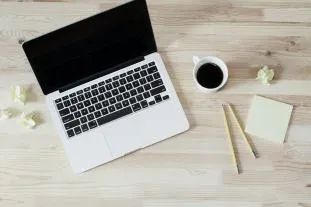 Person arbeitet am Laptop mit Kopfhörern im Onlinekurs