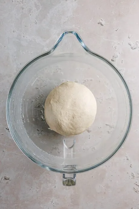 Portionierter Hefeteig wird zu Knödelrollen geformt