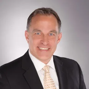 Porträt von John Nixon, einem Energie- und Versorgungsexperten bei Siemens Digital Industries Software, vor einem neutralen Hintergrund.