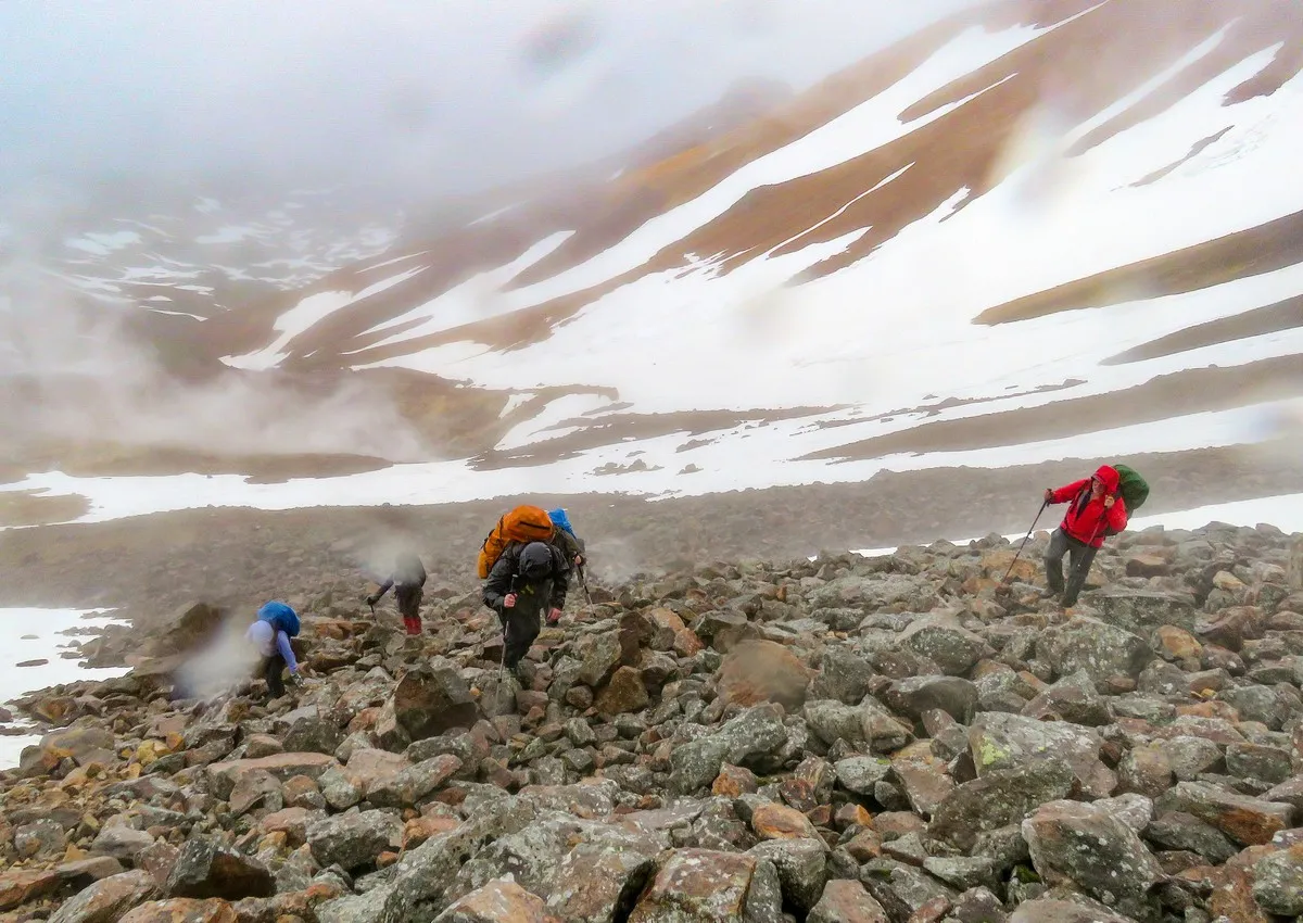 Regennasse, unscheinbare Felsen auf einem Vulkanhang, früher leuchtend orange