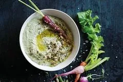 Rezeptbild: Kürbiskern-Dip in einer kleinen Schale auf einem Holzbrett