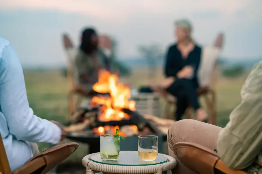 Safari-Gäste am Abend am Feuer