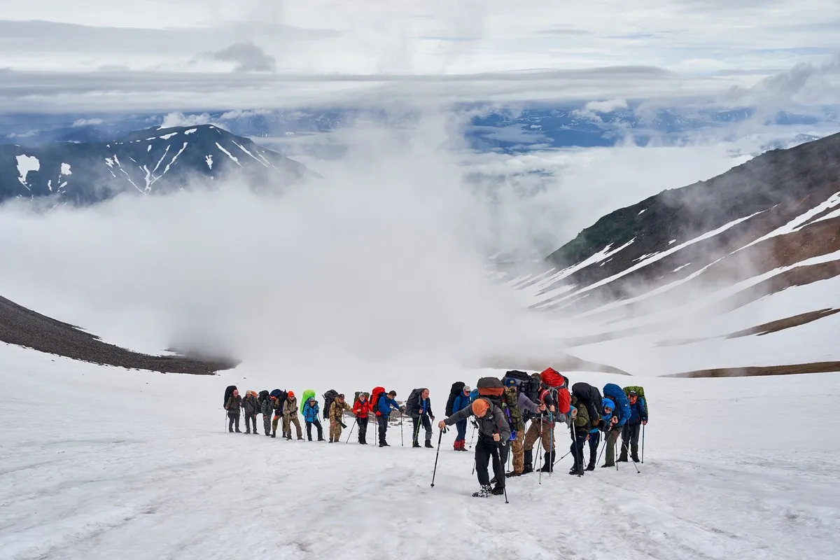 Schneebedeckte Vulkanlandschaft auf Kamtschatka unter dichten Wolken