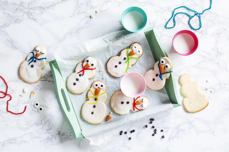 Schneemann-Plätzchen aus Mürbeteig, verziert mit Zuckerguss