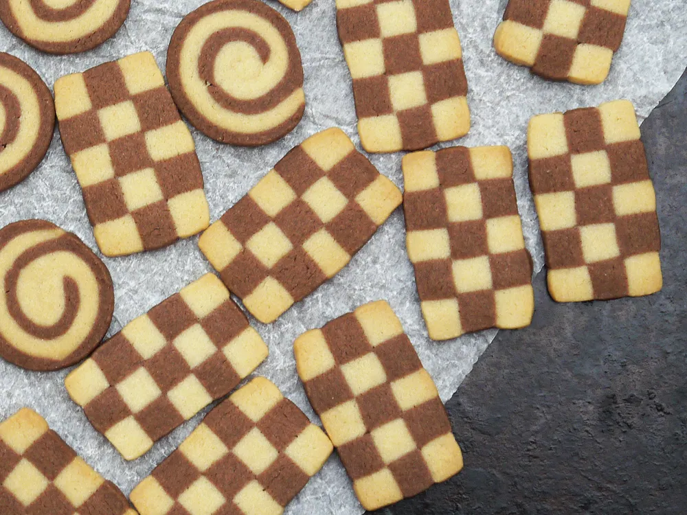 Schnittbilder von Schwarz-Weiß-Gebäck mit Schachbrett- und Spiralmuster, vor und nach dem Backen