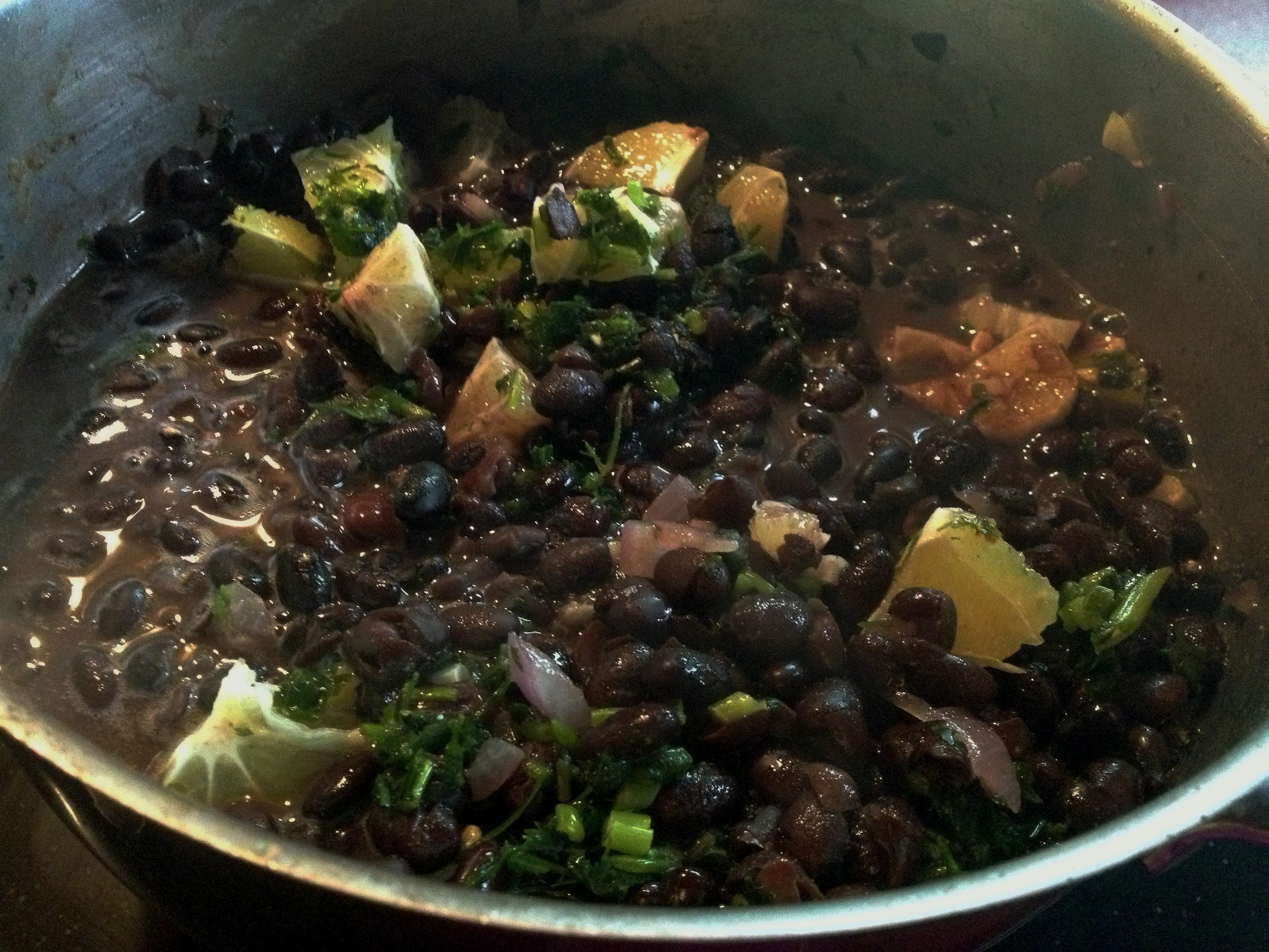 Schwarze Bohnen mit Limette und Koriander in einer gusseisernen Pfanne, appetitlich angerichtet