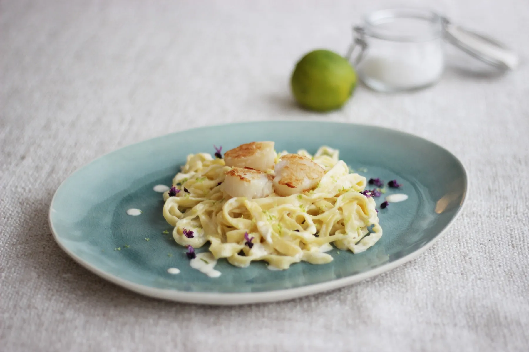 Selbstgemachte Tagliatelle mit Limonensauce und gebratenen Jakobsmuscheln