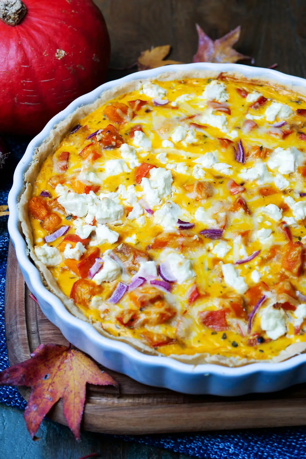 Servierfertige Kürbis-Quiche in einer Form mit goldenem Rand, bereit zum Anschneiden