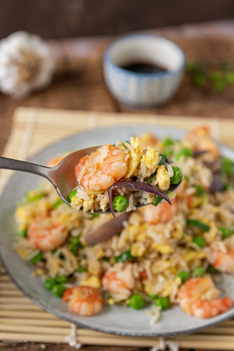 Servierter gebratener Reis mit Garnelen, Gemüse und Spiegelei.