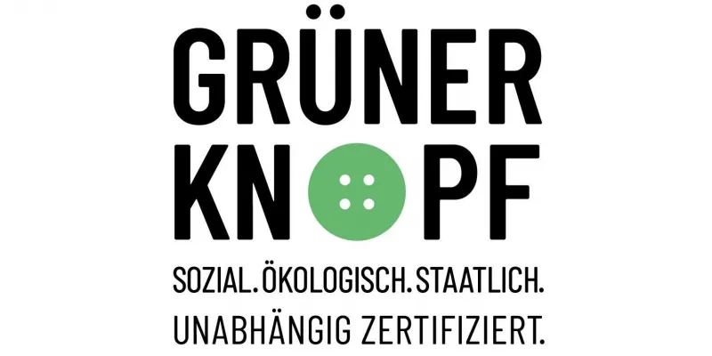 Siegel Grüner Knopf für Textilien, das einen grünen Knopf mit der Aufschrift „Grüner Knopf“ zeigt.