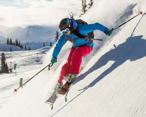 Skifahrer und Snowboarder genießen die Pisten vor einer verschneiten Bergkulisse