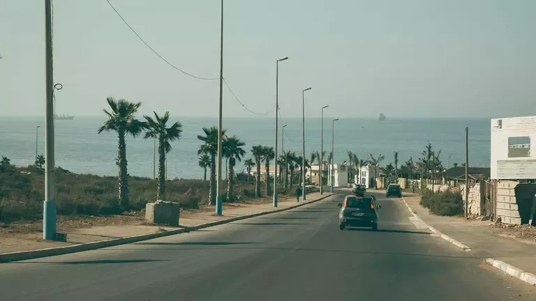 Surfer am Pointbreak in Anza, Marokko, mit Wellen und Küstenlandschaft im Hintergrund