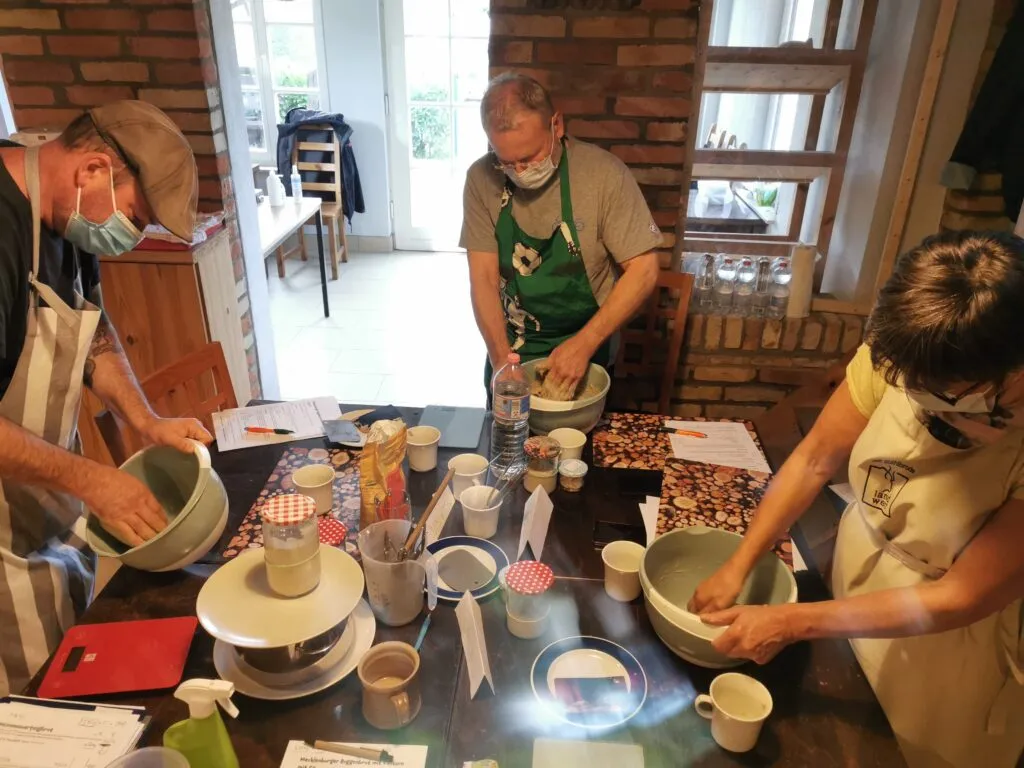 Teilnehmer kneten Teig intensiv mit den Händen