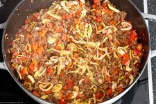 Tomatenmark und gewürfeltes Gemüse werden mit dem Hackfleisch angebraten