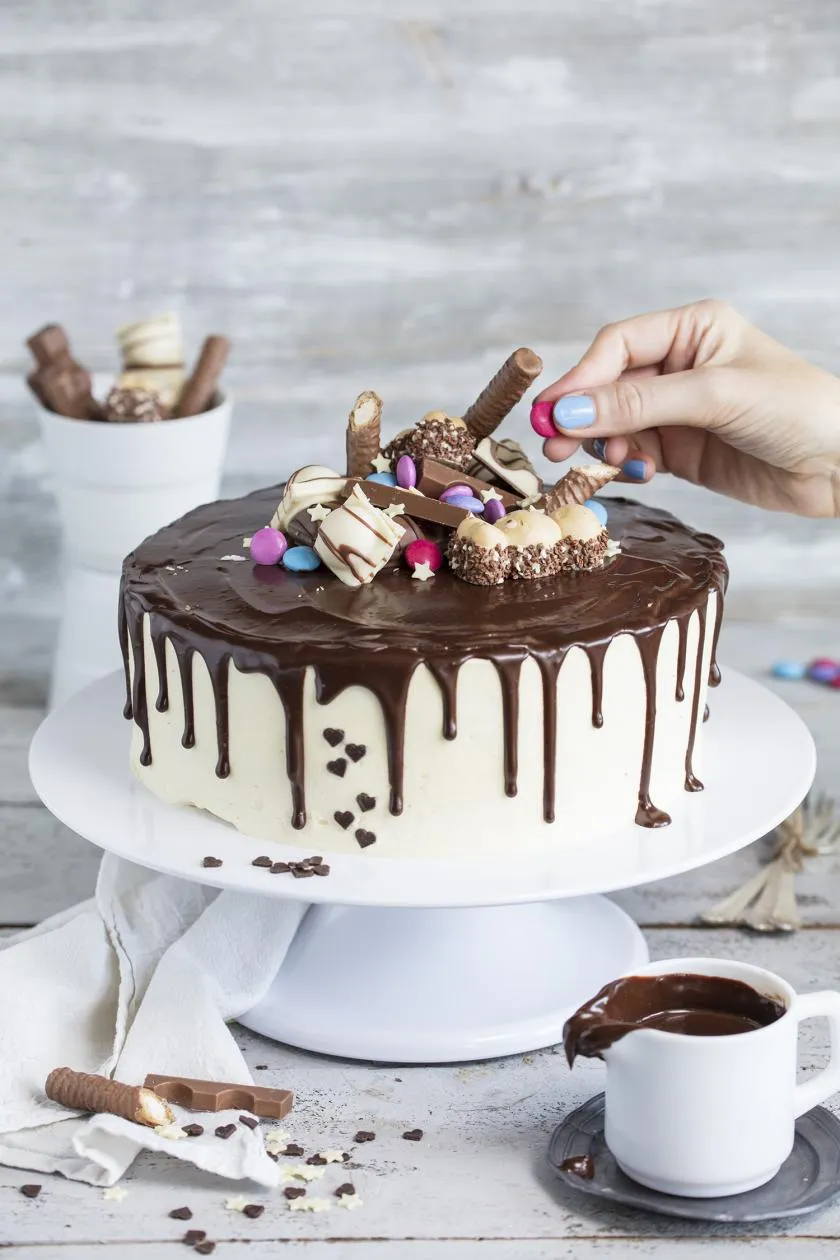 Trendiger Drip Cake mit Schokoriegeln, auch für eine größere Kindergeburtstagsfeier geeignet.