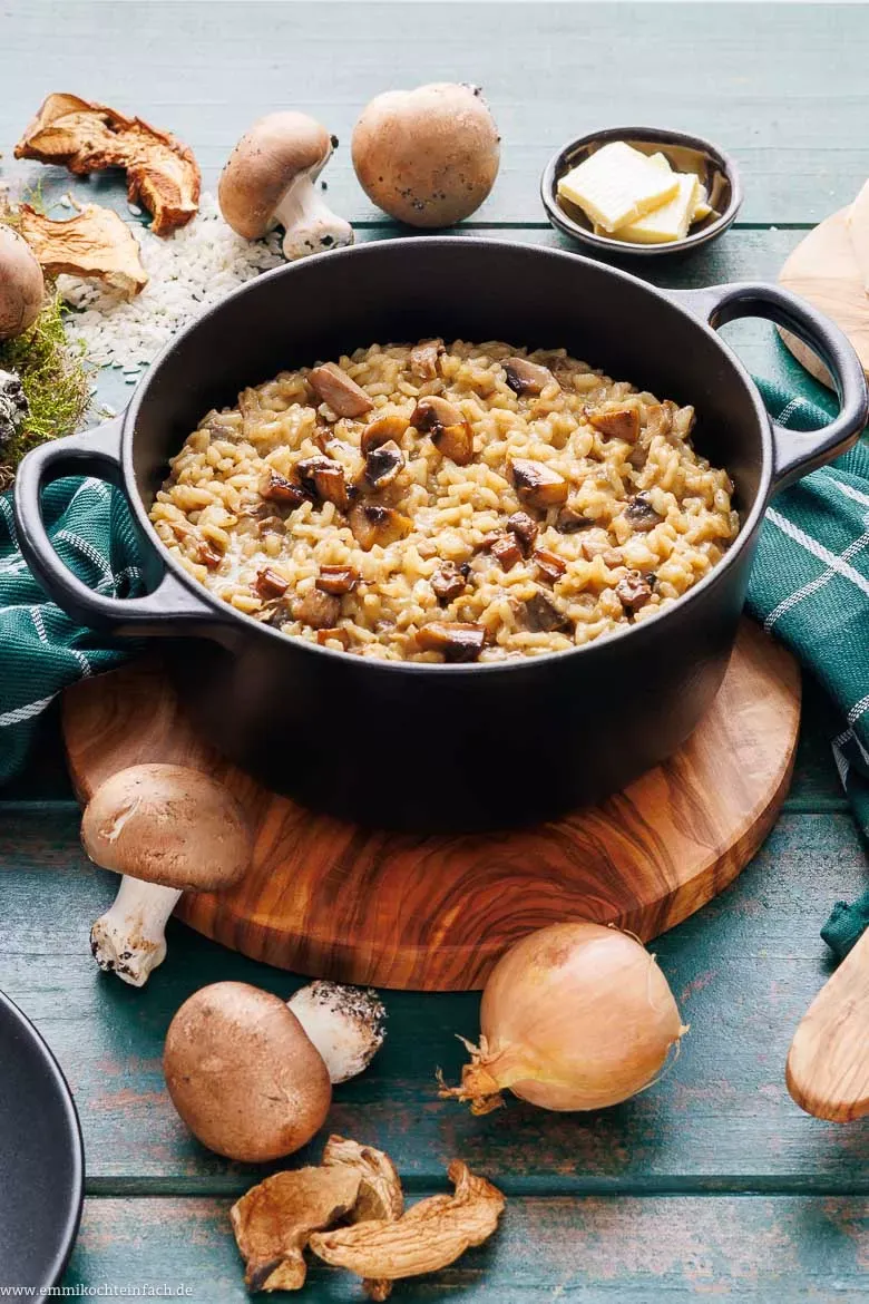 Verschiedene Zutaten für Pilzrisotto: Reis, Parmesan, Zwiebeln