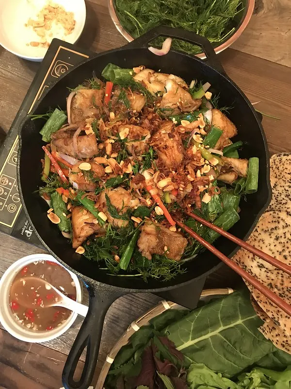 Zarte, in Kurkuma marinierte Fischstücke werden in einer Pfanne goldbraun gebraten