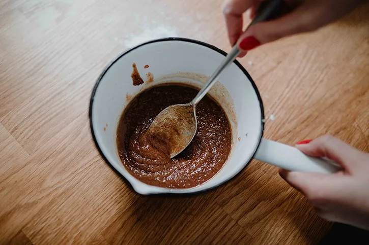 Zimtschneckenfüllung aus geschmolzener Butter, Rohrzucker und Zimt in einem Topf, bereit zum Bestreichen des Hefeteigs.