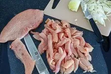 Zubereitung des Gyros: Fleisch und Zwiebeln werden für die Marinade vorbereitet