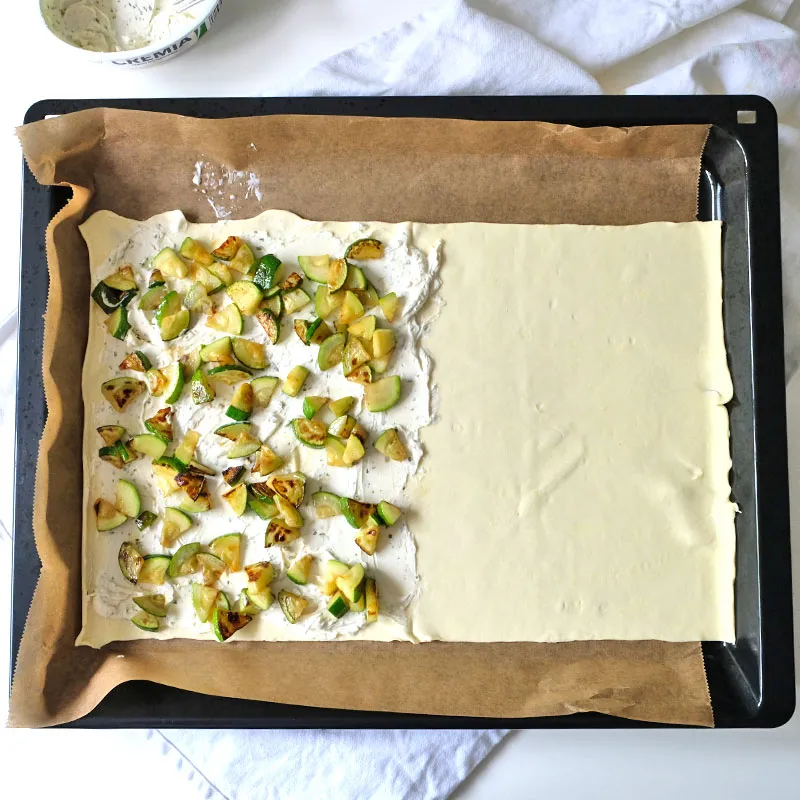 Zubereitungsschritt: Blätterteig mit Frischkäse, Zucchini und Cheddar belegt