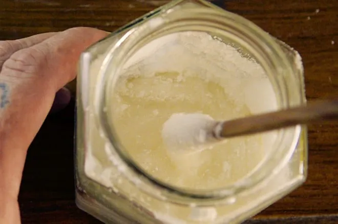 Zutaten für Gummibärchen werden in einem Glas im Wasserbad erhitzt.