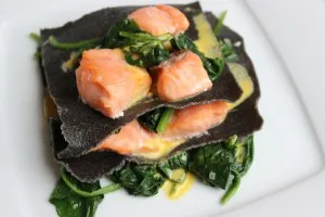 Zutaten für hausgemachten schwarzen Nudelteig, darunter Mehl, Eier und Sepiatinte, vorbereitet für Spinat Lachs Lasagne.