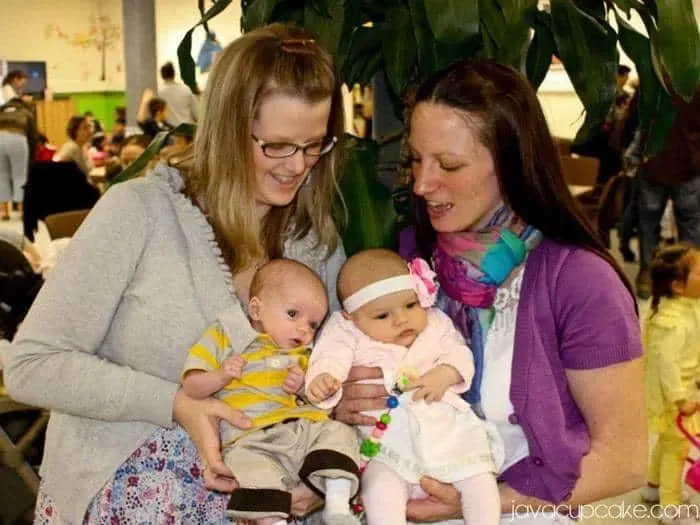 Zwei Erwachsene und zwei Kinder posieren stolz mit einem festlich geschmückten Osterlamm Kuchen