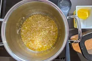 Zwiebelwürfel in Butterschmalz in einem Topf andünsten