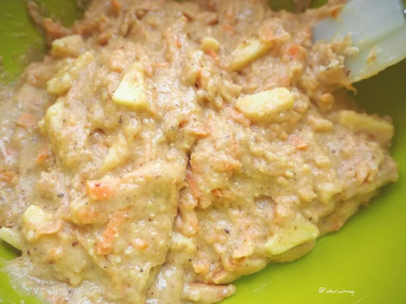 Zwölf Muffinförmchen gefüllt mit Karotten-Apfel-Nuss-Teig