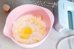 Kalte Butter und Ei zum Teig in die Schüssel geben