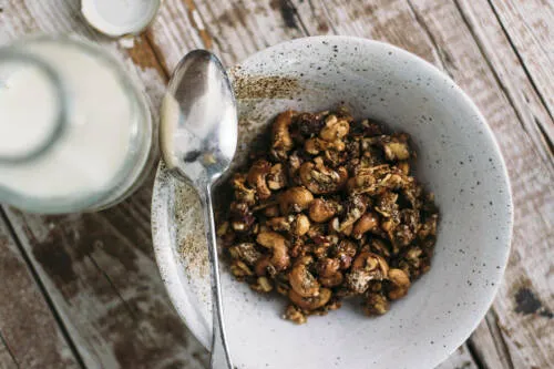 Nuss-Chia-Granola in weißer Schüssel vor hellem Hintergrund.