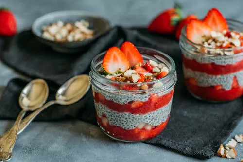 Sweet Earl Grey Frühstück in Gläsern mit Chiasamen vor dunklem Hintergrund.