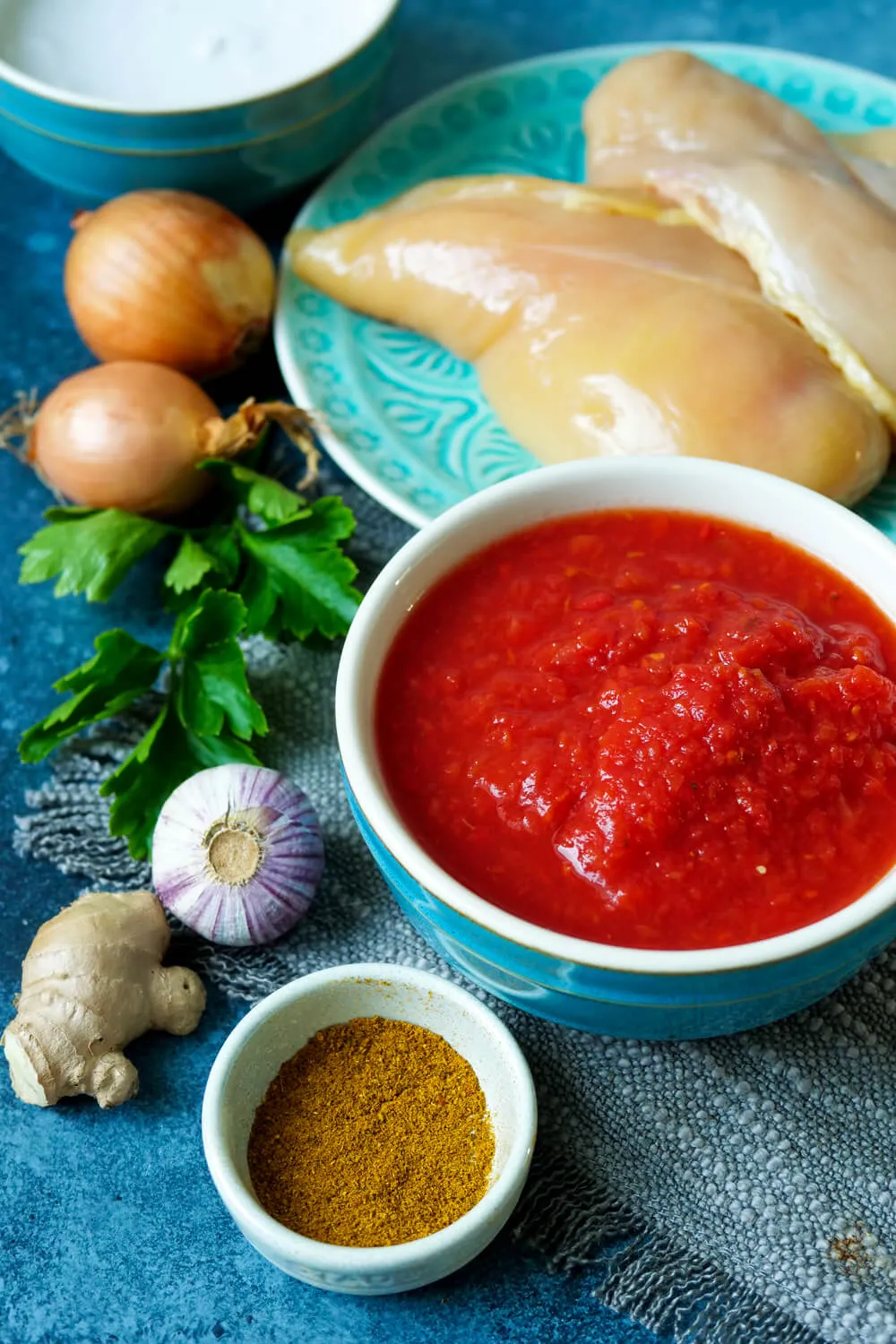 Alle frischen Zutaten für ein indisches Curry: Ingwer, Knoblauch, Zwiebeln, Hähnchen, Kokosmilch