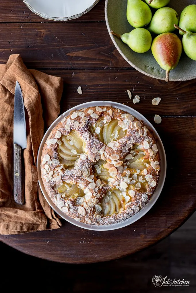 Birnen-Mandel-Kuchen während der Zubereitung mit pochierten Birnen