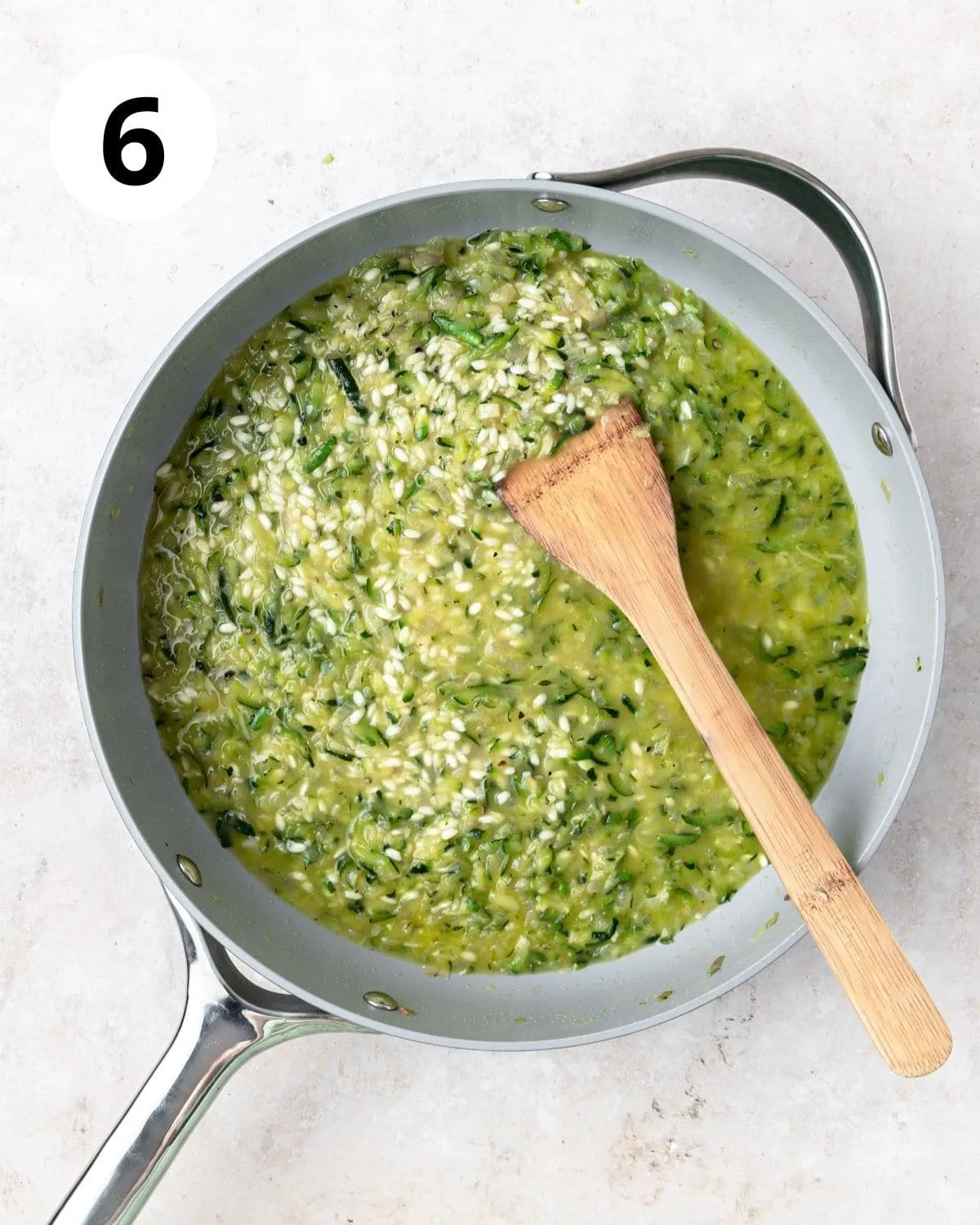 Brühe zum Zucchini Risotto hinzufügen.