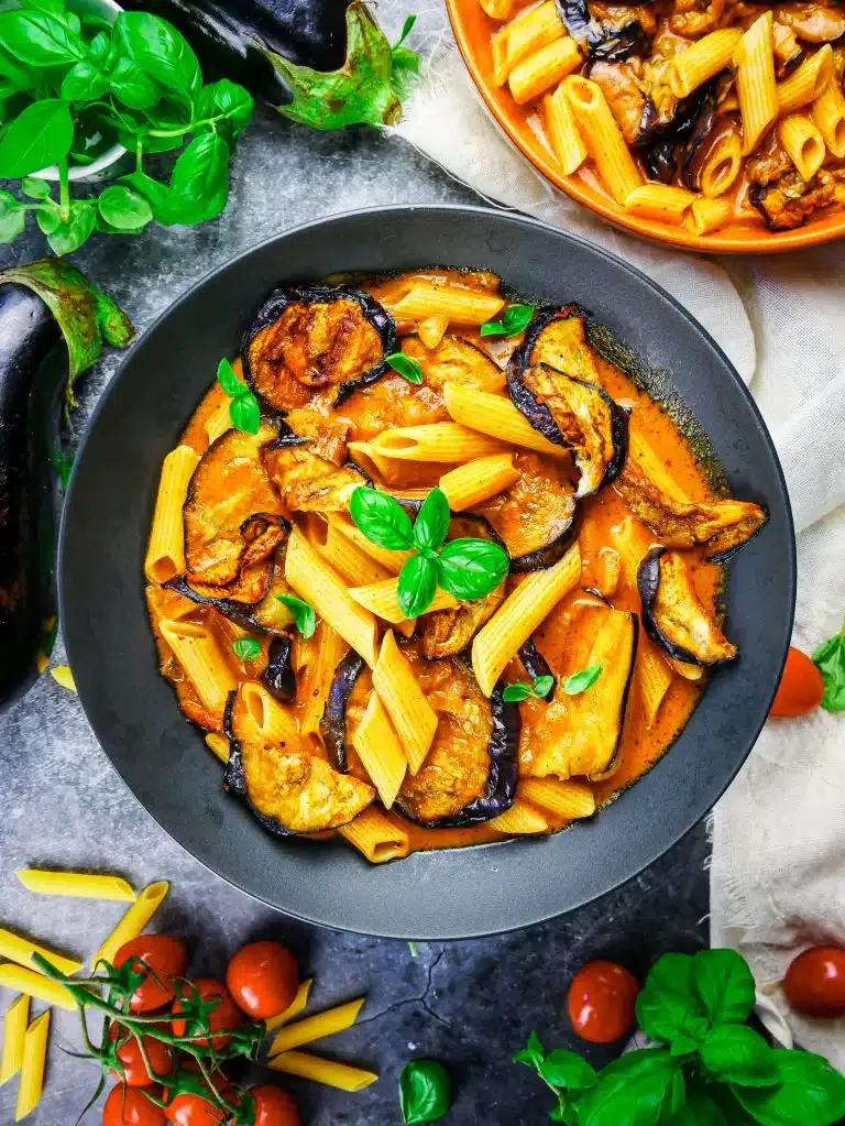 Cremige Auberginen-Pasta in einer tiefen Schüssel mit frischem Basilikum