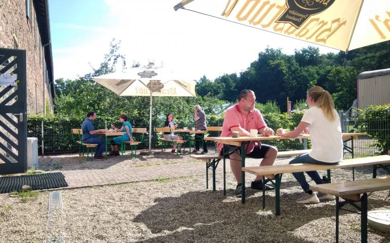 Der einladende Biergarten des Café Kranich mit Sonnenschirmen