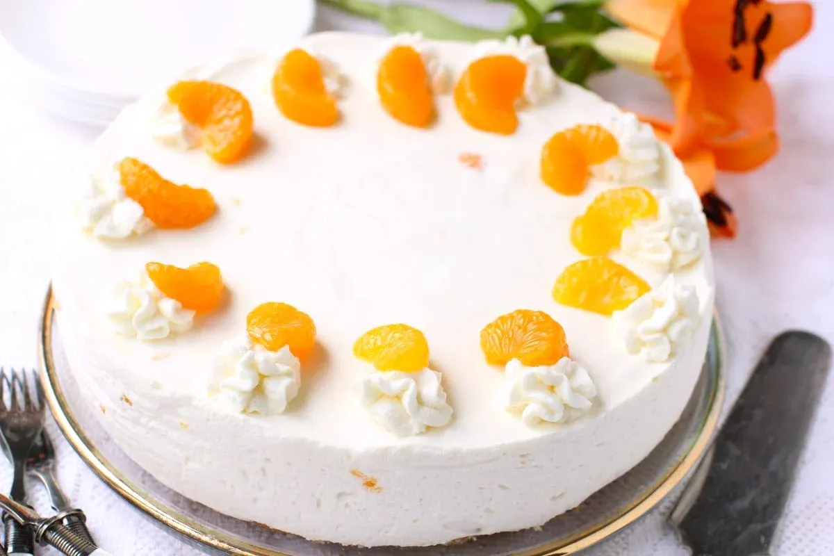 Die ganze Mandarinen-Sahnetorte, dekoriert und bereit zum Anschneiden.