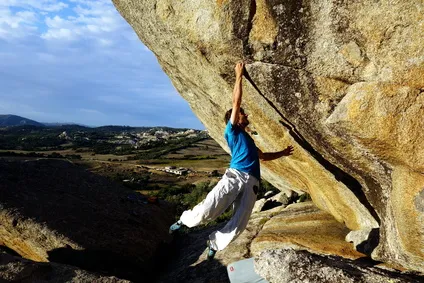Ein Freeclimber klettert an einer steilen Felswand ohne sichtbare Sicherung