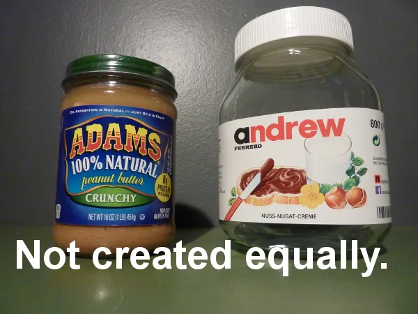 Ein Glas Nutella neben einem Glas Erdnussbutter auf einem Holztisch