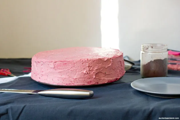 Ein imposantes Stück Schoko-Himbeer-Torte mit dunklen Böden und rosa Creme