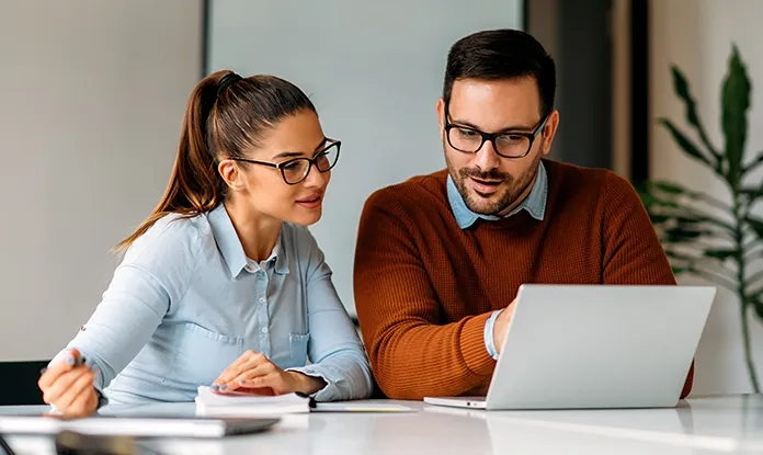Ein Paar betrachtet Dokumente, die die Entscheidung für eine fondsorientierte Lebensversicherung darstellen